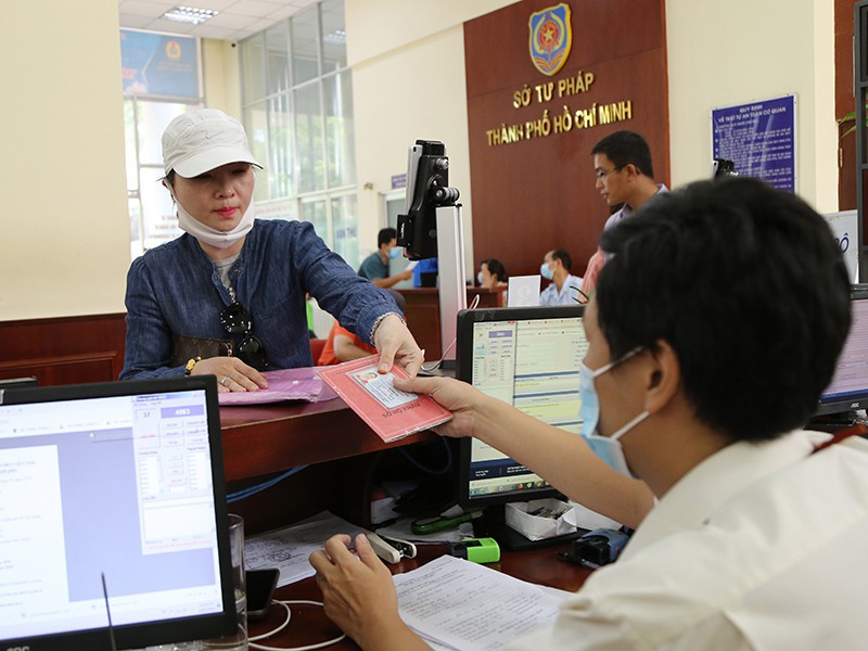 Người dân xuất trình sổ hộ khẩu khi làm thủ tục tại Sở Tư pháp TP.HCM